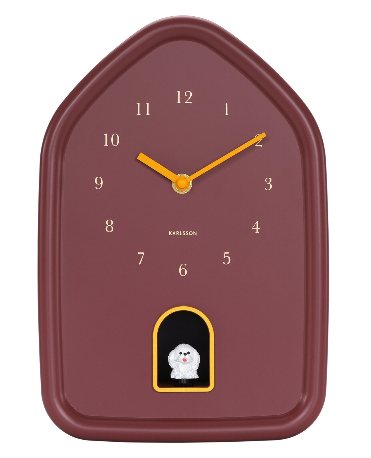 Moderne Wanduhr in Hausform mit braunem Zifferblatt und gelben Zeigern, frontal abgebildet. Unterhalb der 6 befindet sich eine kleine weiße Figur in einem gelben Rahmen.