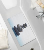 Perspektive von oben auf eine Wanneneinlage mit einem Zen-Steine-Motiv in einer Badewanne.