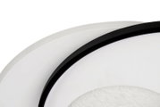 Close-up van een moderne led-plafondlamp met een zwarte rand en een wit oppervlak, gezien vanaf de zijkant