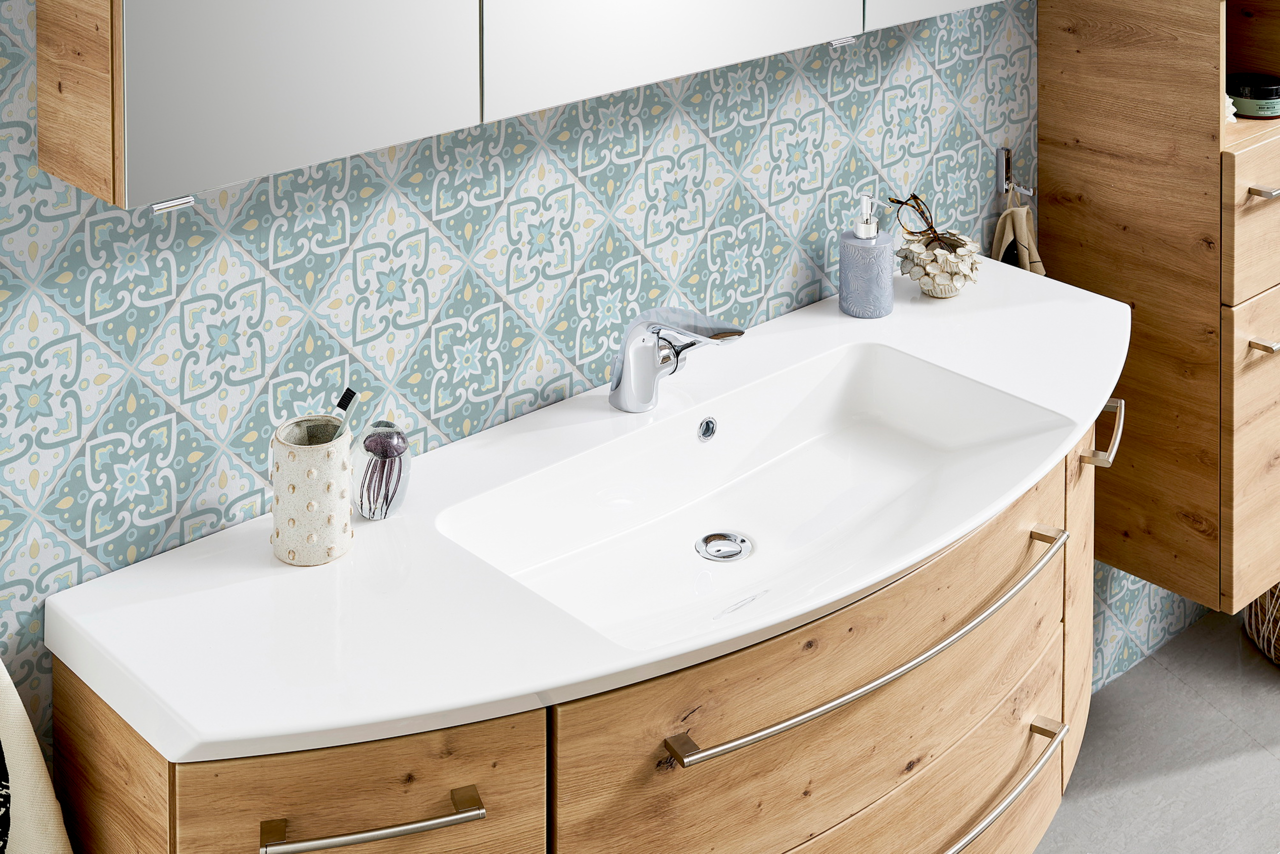 Moderne Badkombination mit geschwungenem Waschbecken und Holzschränken, seitliche Perspektive