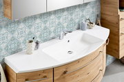 Moderne Badkombination mit geschwungenem Waschbecken und Holzschränken, seitliche Perspektive
