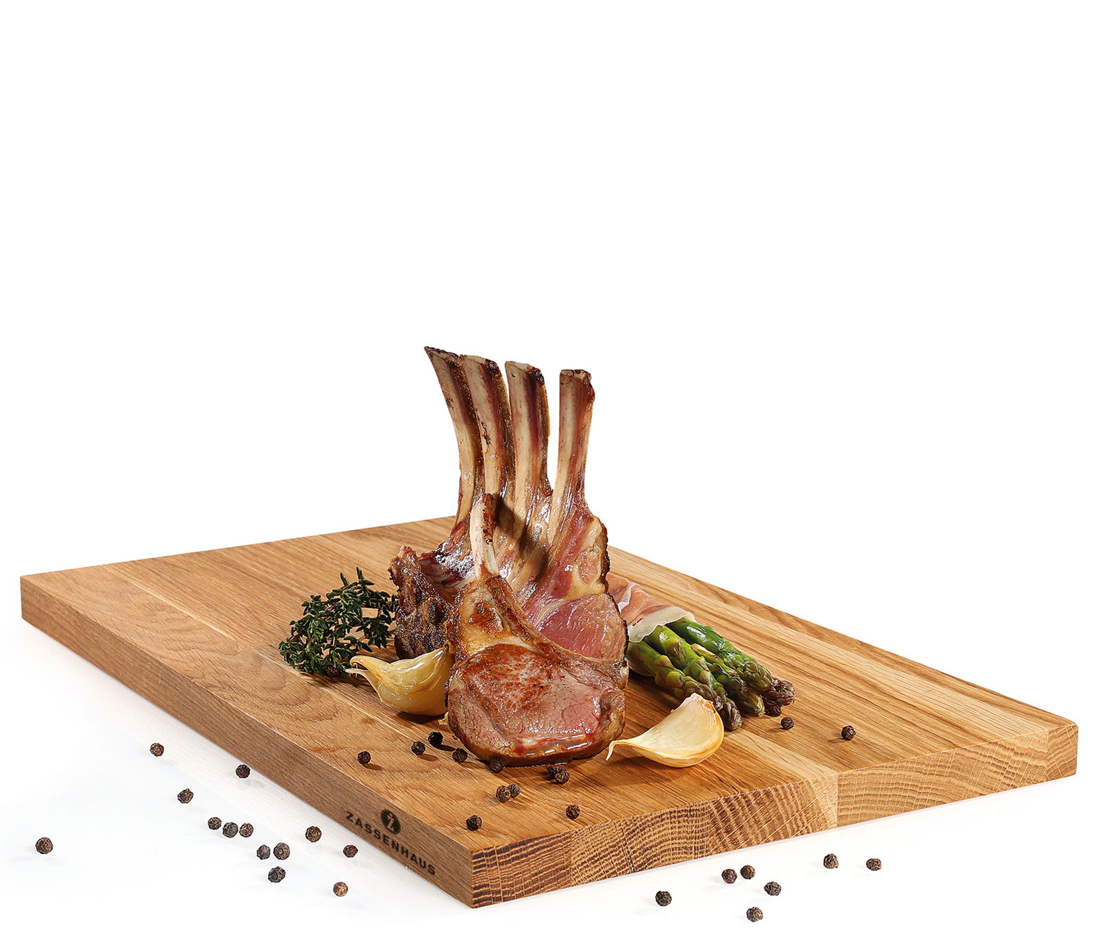 Schneidbrett aus Eiche mit Lammkoteletts, Spargel und Gewürzen, seitliche Perspektive