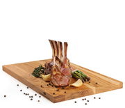 Schneidbrett aus Eiche mit Lammkoteletts, Spargel und Gewürzen, seitliche Perspektive