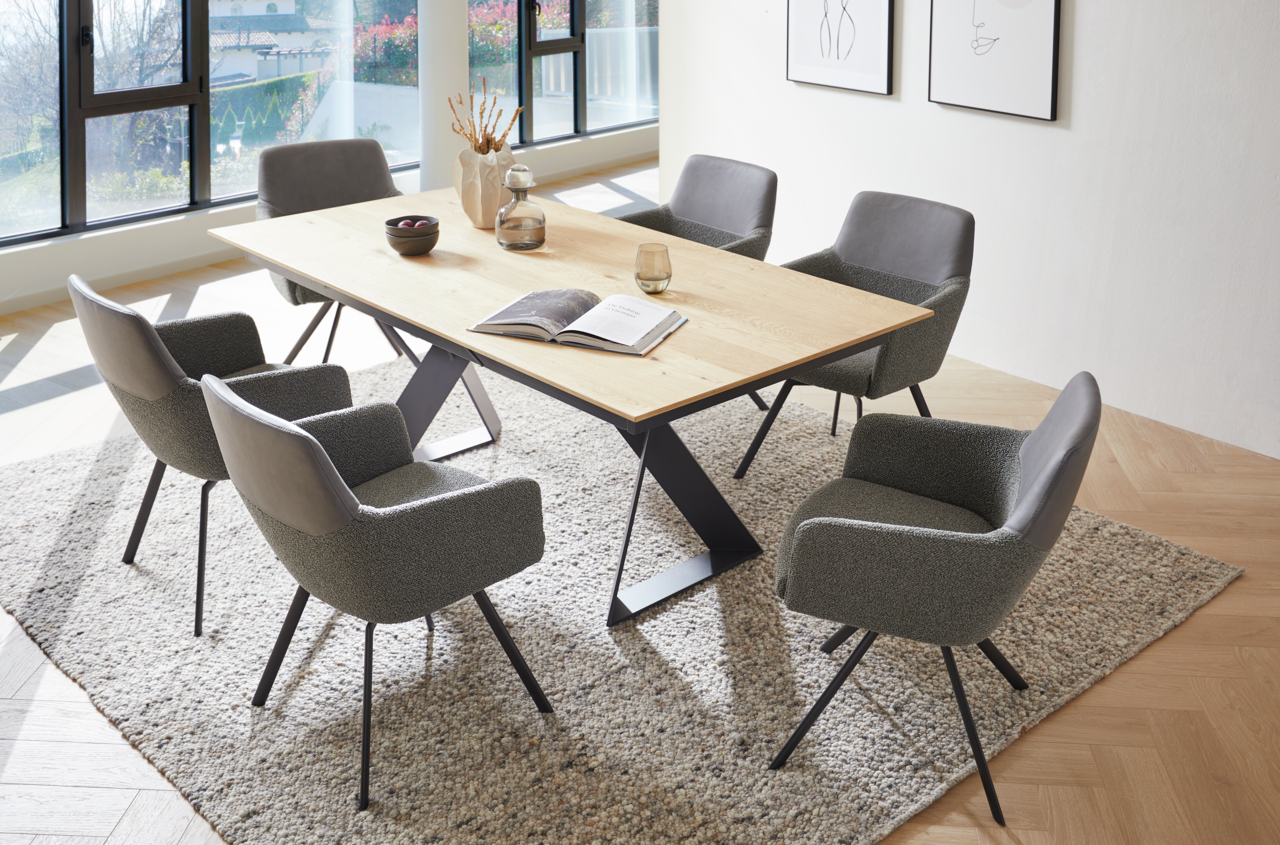 Venjakob Esstisch ETG61 Moderner Esstisch mit Holzplatte und schwarzen Metallbeinen, umgeben von sechs grauen Stühlen in einem hellen Raum mit großen Fenstern, aus der Vogelperspektive fotografiert.