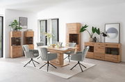 Esszimmer mit moderner Holzmöbelkombination, bestehend aus einem Tisch, Stühlen, Highboard, Vitrine und Sideboard, aus der Perspektive des Raumes fotografiert.
