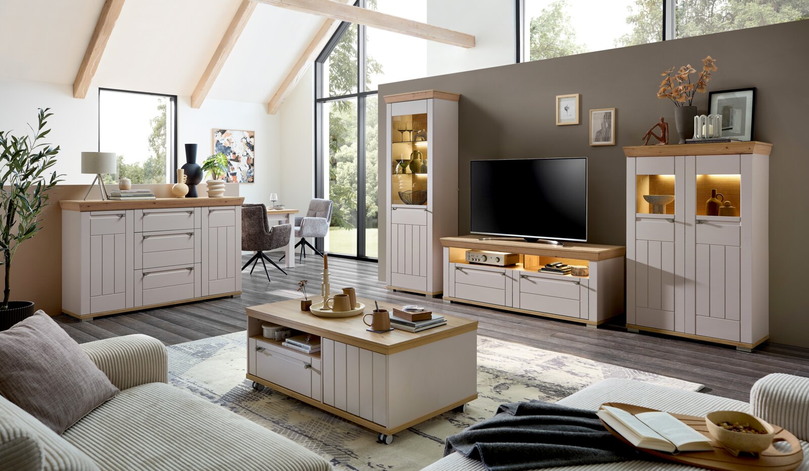 Moderne Wohnzimmer-Wandkombination in heller Holzoptik mit TV-Schrank, Vitrinen und Couchtisch, seitliche Perspektive