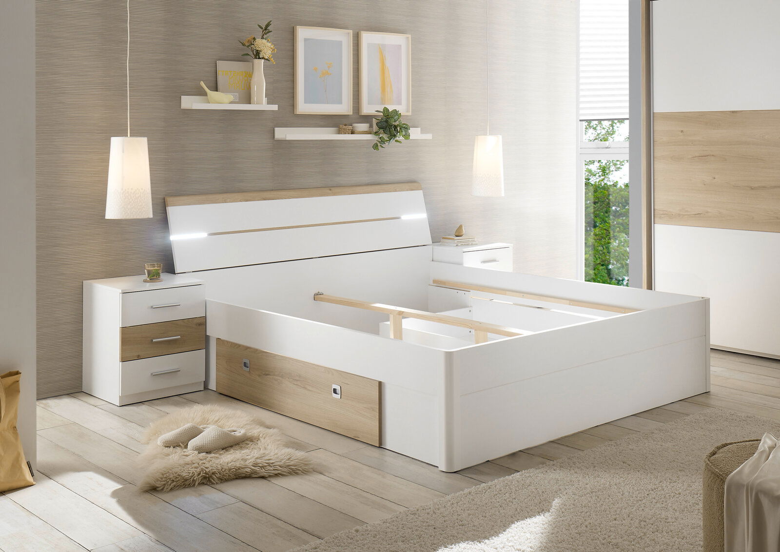 Modernes Schlafzimmer mit einem weißen und holzfarbenen Bettgestell, flankiert von zwei Nachttischen. Perspektive von vorne rechts.