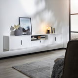 Modernes weißes TV-Hängeboard mit drei Türen und einem offenen Fach, dekoriert mit Vasen, Büchern und einer Lampe, seitliche Perspektive.