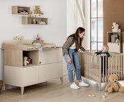 Kinderzimmer mit Wandboxen, Wickelkommode und Gitterbett, seitliche Perspektive