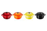 Vier Mini-Cocottes in verschiedenen Farben (Rot, Orange, Gelb, Schwarz) aus der Vogelperspektive.