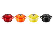 Vier Mini-Cocottes in verschiedenen Farben (Rot, Orange, Gelb, Schwarz) aus der Vogelperspektive.