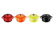 Vier Mini-Cocottes in verschiedenen Farben (Rot, Orange, Gelb, Schwarz) aus der Vogelperspektive.