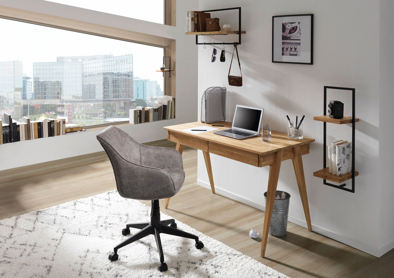 Moderner Schreibtisch aus Holz mit Laptop und Glas, seitliche Perspektive.