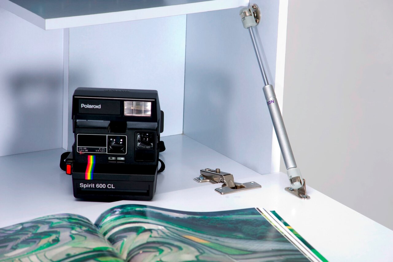 Polaroid Spirit 600 CL Kamera in einem weißen Regal, seitliche Perspektive