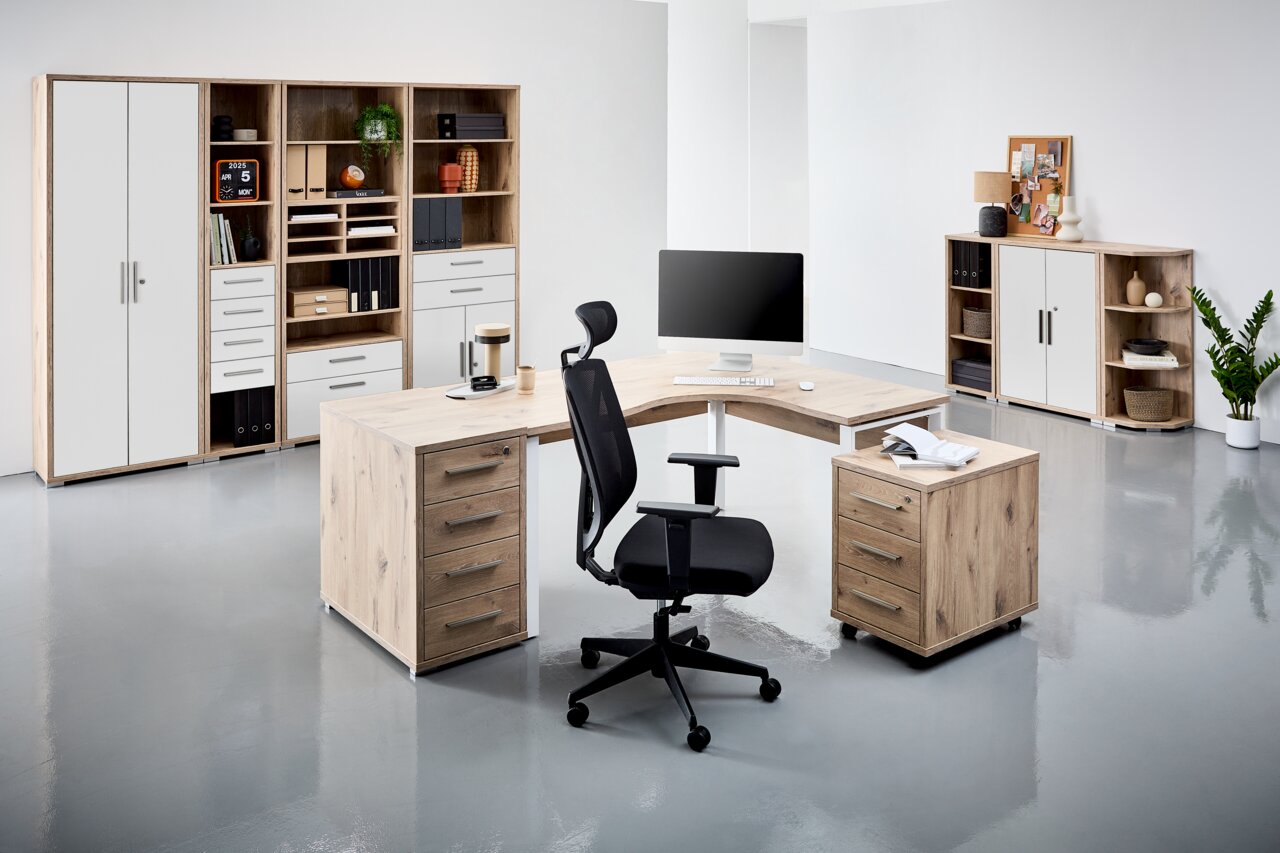 Moderne Büroumgebung mit einem Eckschreibtisch in Holzoptik, umgeben von Regalen und Schränken. Perspektive von vorne links.