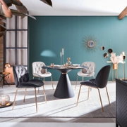 Esszimmer mit modernem Tisch und vier eleganten Stühlen in verschiedenen Farben, seitliche Perspektive