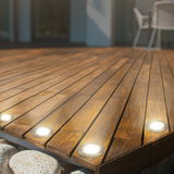 Eingelassene Edelstahl-Deckleuchten auf einer Holzterrasse, seitliche Perspektive