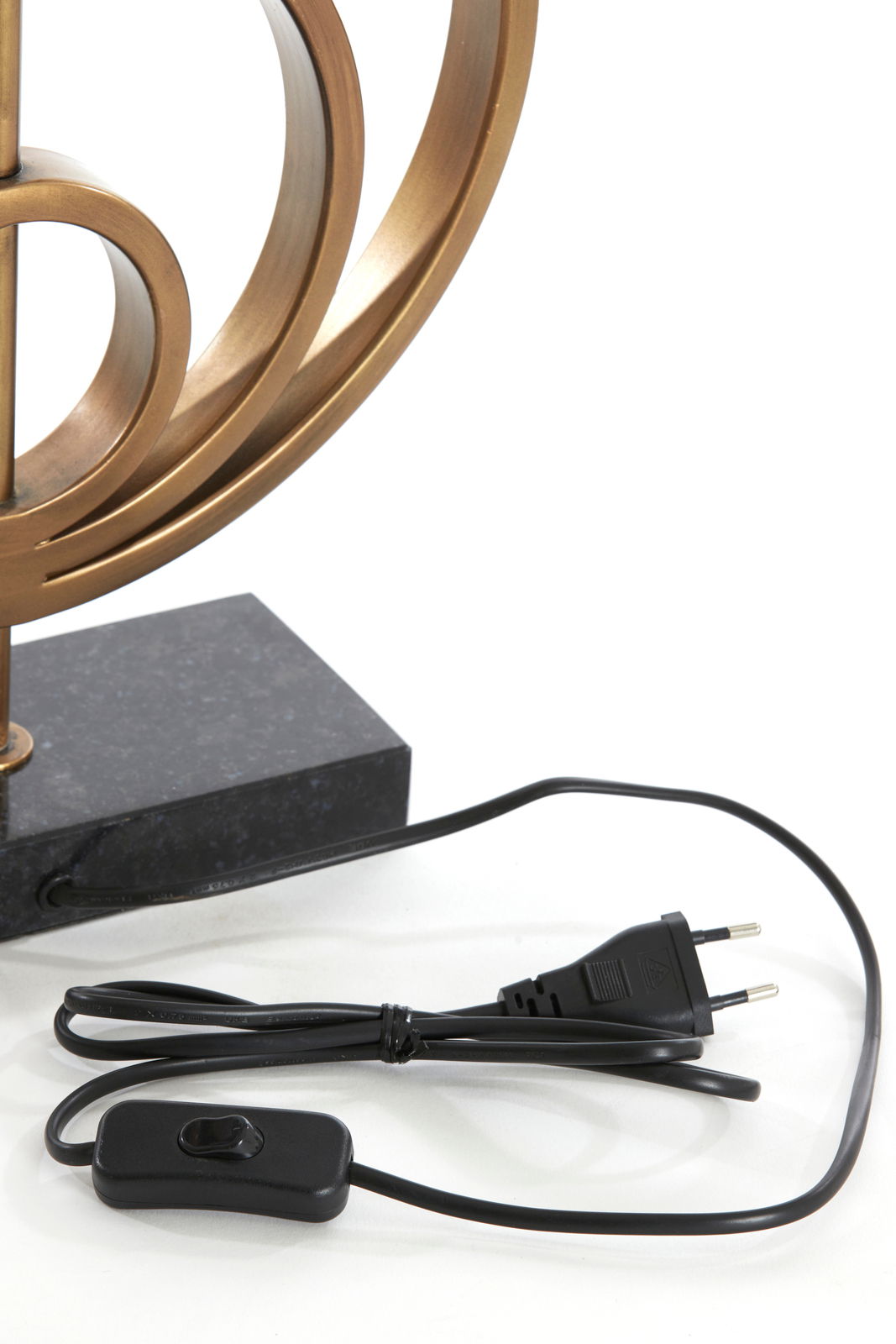 Nahaufnahme eines Lampenfußes mit geschwungenem, bronzefarbenem Design und schwarzem Kabel mit Schalter und Stecker.