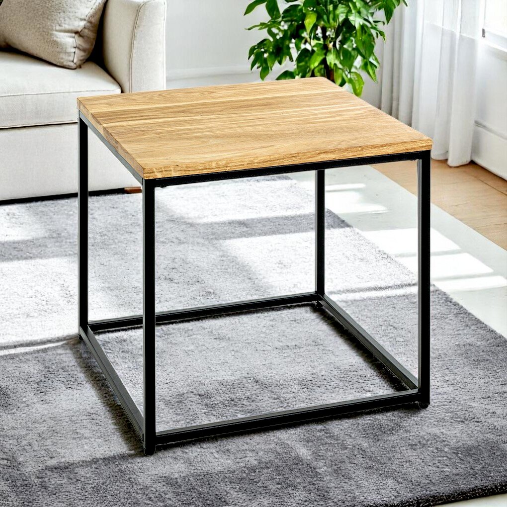 Moderner Beistelltisch mit rechteckiger Holzplatte in Eiche-Optik und schwarzem Metallgestell im Wohnzimmer auf grauem Teppich, schräg von vorne aus leicht erhöhter Perspektive fotografiert