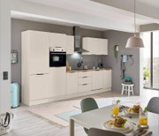 Moderne Einbauküche in heller Farbe mit integriertem Backofen und Kühlschrank, Dunstabzugshaube und Arbeitsplatte aus Holz. Perspektive von der Seite mit Blick auf den Esstisch im Vordergrund.