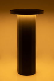 Moderne Akku-Tischleuchte mit zylindrischem Design, seitliche Perspektive, warmes Licht abstrahlend.