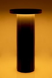 Moderne Akku-Tischleuchte mit zylindrischem Design, seitliche Perspektive, warmes Licht abstrahlend.