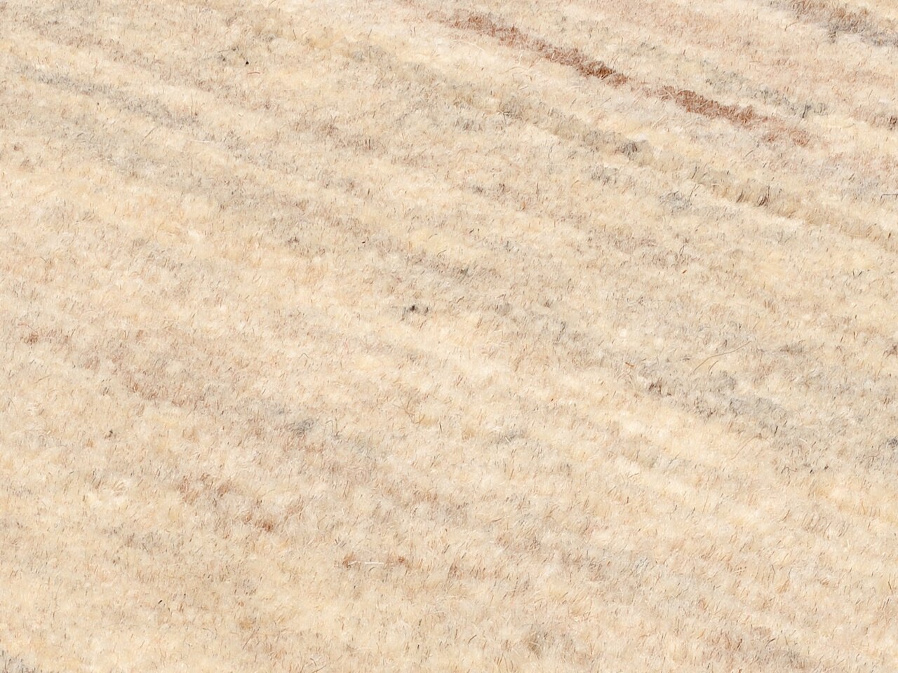 Nahaufnahme eines beigen Wollteppichs mit feiner Textur und leichtem Farbverlauf, diagonale Perspektive