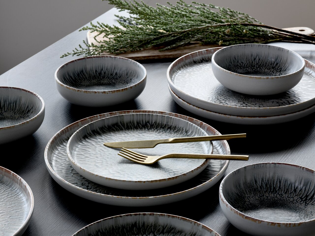 Elegantes Tellerset mit 12 Teilen in moderner Keramikoptik, aus der Vogelperspektive fotografiert.