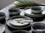 Elegantes Tellerset mit 12 Teilen in moderner Keramikoptik, aus der Vogelperspektive fotografiert.