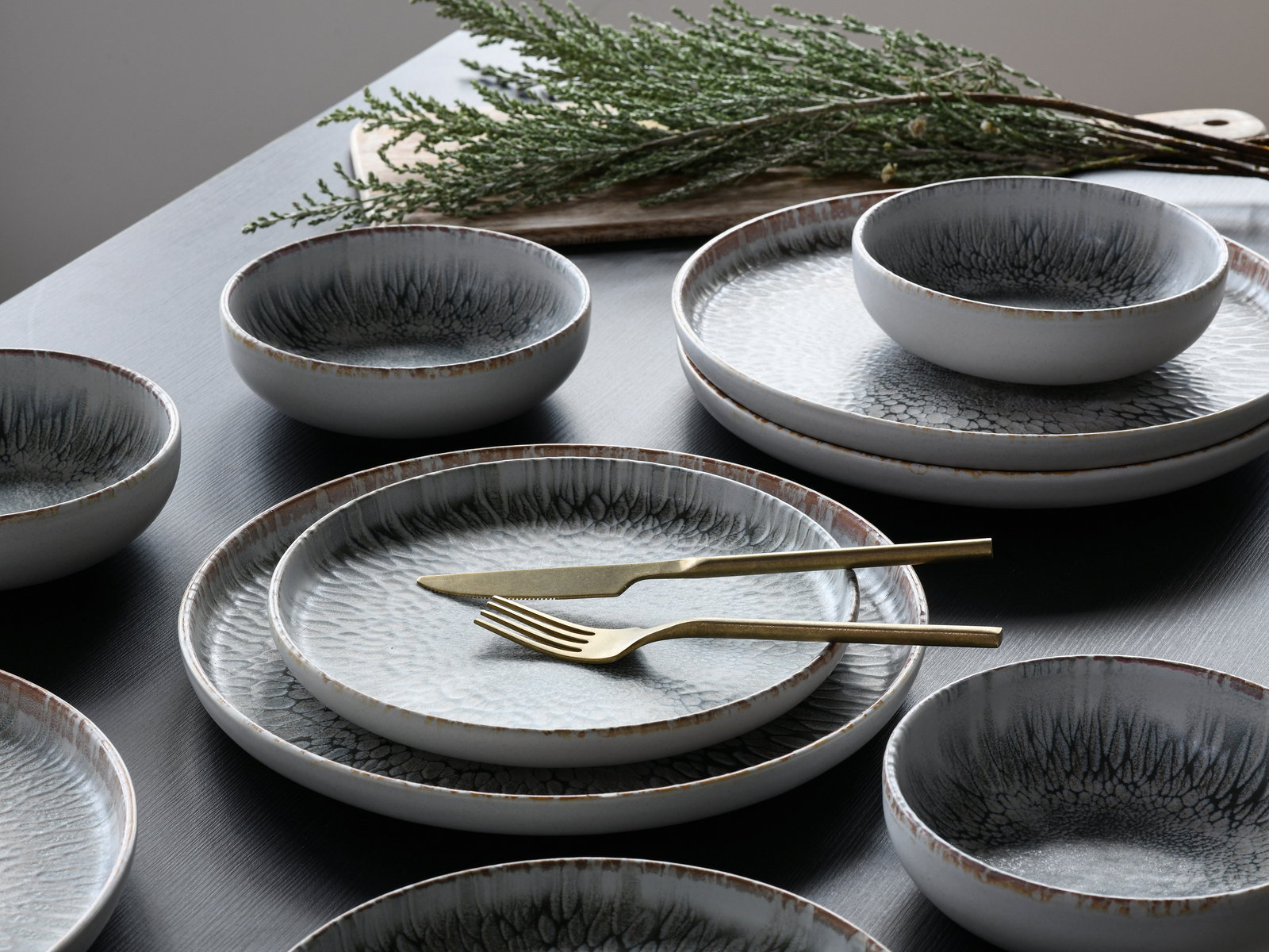 Elegantes Tellerset mit 12 Teilen in moderner Keramikoptik, aus der Vogelperspektive fotografiert.