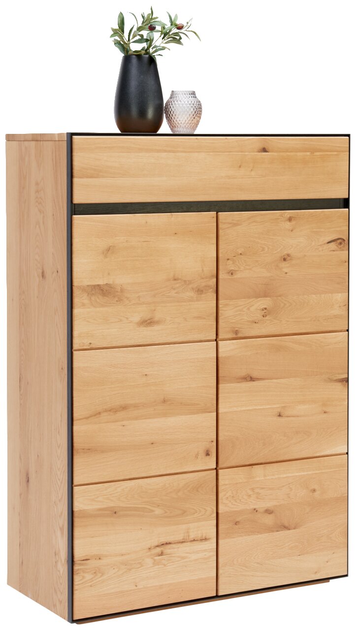 Hochkommode aus hellem Holz mit schwarzen Akzenten, dekoriert mit einer schwarzen Vase und einem Glasgefäß, seitliche Perspektive.