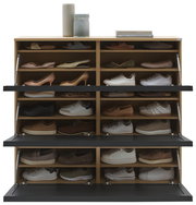 Schuhschrank mit mehreren Fächern, gefüllt mit verschiedenen Schuhen, aus der Frontalperspektive fotografiert.