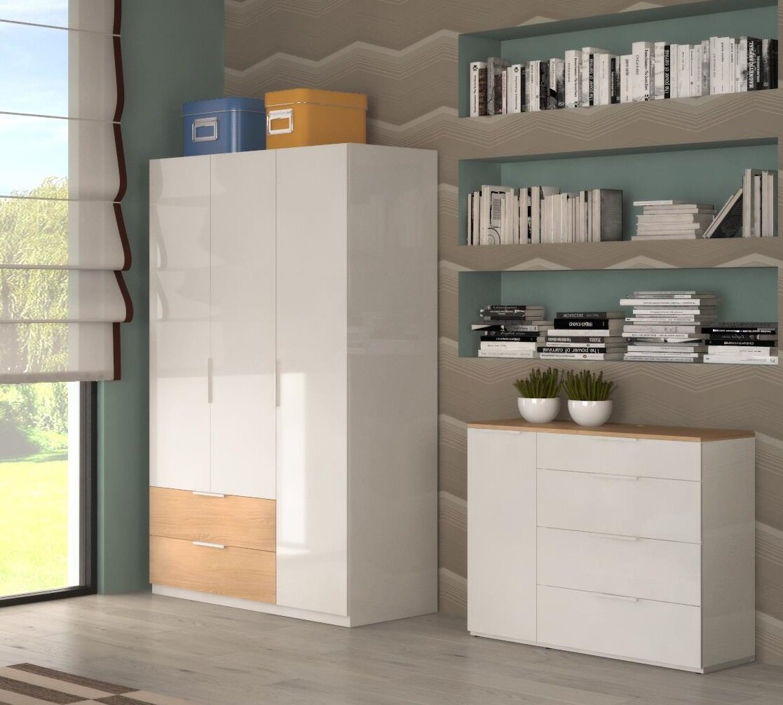 Modernes Wohnzimmer-Set mit weißem Kleiderschrank und passender Kommode mit Holzoptik-Akzenten, dekoriert mit Boxen, Büchern und Pflanzen Perspektive: leicht schräg von vorn (Front-/Seitenansicht)