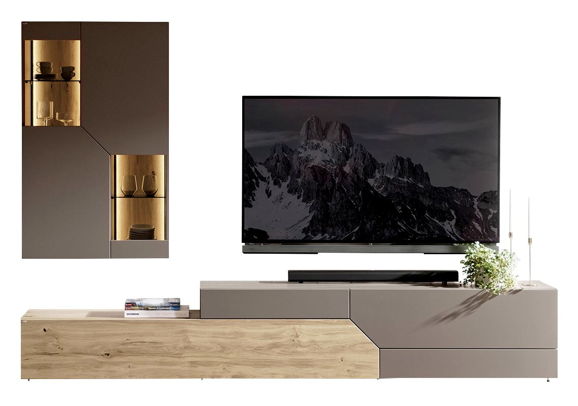 Modern tv-lowboard in houtlook en matgrijs met een asymmetrisch ontwerp, met daarop een tv; links twee bijpassende hangkasten met verlichte glazen vitrines, vooraanzicht.