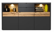 Vooraanzicht van een modern hoogkast met donkere deuren en houten details, verlichte vakken en decoratieve voorwerpen.