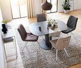 Esszimmer mit modernem Tisch und vier gepolsterten Stühlen in verschiedenen Farben, von oben betrachtet.