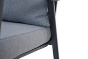 Nahaufnahme eines grauen Comfort Plus Stapelsessels mit gepolstertem Sitz und Rückenlehne, seitliche Perspektive