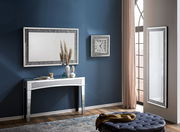 Eleganter Konsolentisch mit Spiegeloberfläche, dekoriert mit Vasen und Kerzen, in einem stilvoll eingerichteten Raum. Perspektive von vorne.