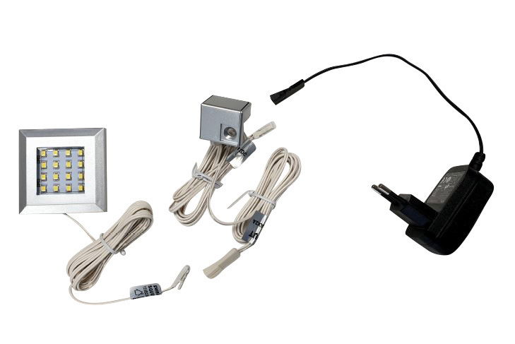 LED-Unterbaubeleuchtung mit Netzteil und Kabeln, aus der Vogelperspektive fotografiert.