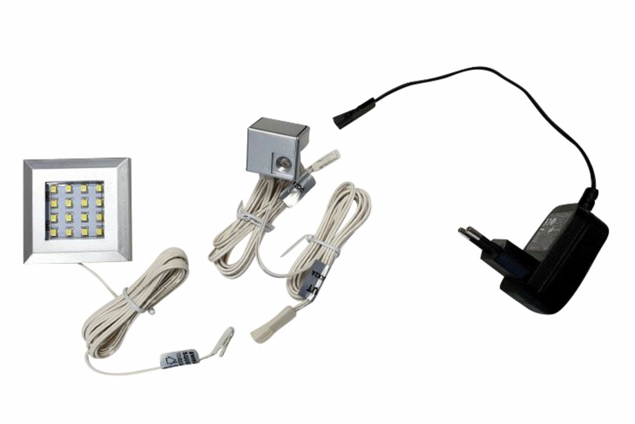 LED-Unterbaubeleuchtung mit Netzteil und Kabeln, aus der Vogelperspektive fotografiert.