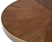 Nahaufnahme eines runden Couchtischs mit Holzfurnier und Metallrand, von oben betrachtet.