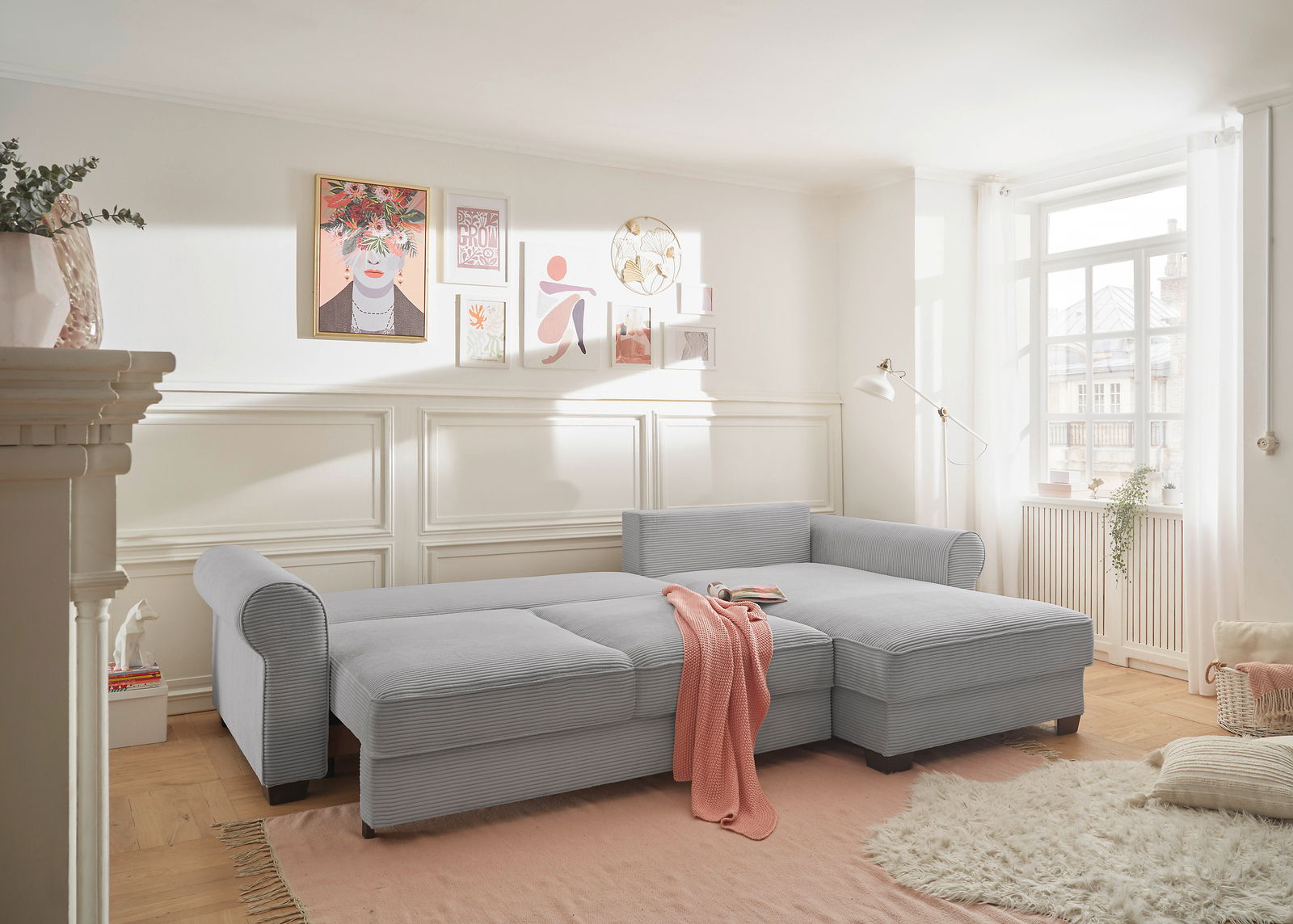 Gemütliche graue Rundecke in einem hellen Wohnzimmer, seitliche Perspektive