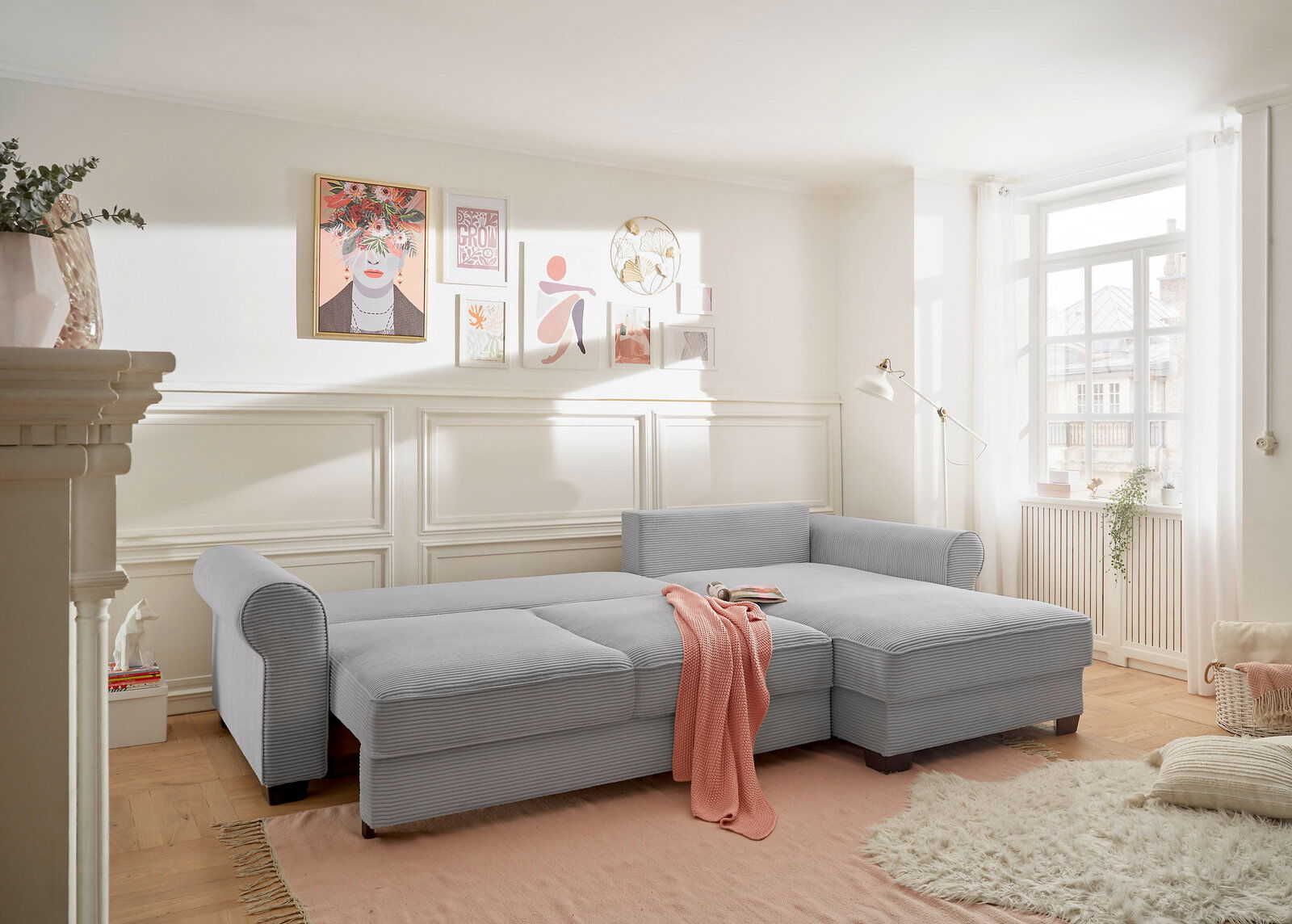 Gemütliche graue Rundecke in einem hellen Wohnzimmer, seitliche Perspektive