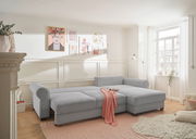 Gemütliche graue Rundecke in einem hellen Wohnzimmer, seitliche Perspektive