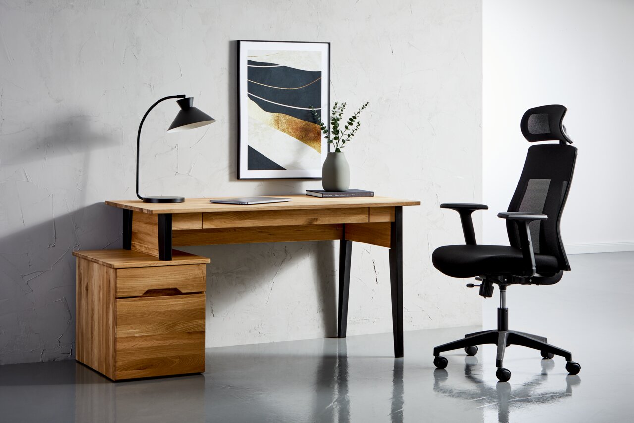 Moderner Schreibtisch aus Holz mit schwarzem Metallgestell, seitlich mit Schubladenblock, im Vordergrund ein ergonomischer Bürostuhl. Perspektive von vorne.