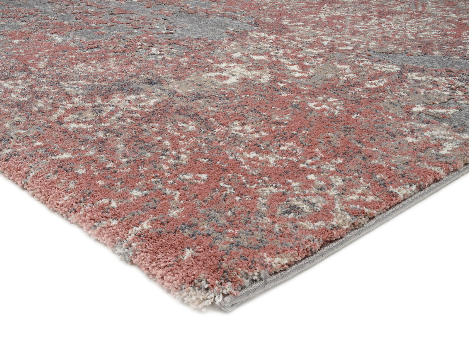 Nahaufnahme eines Designer Teppichs mit abstraktem Muster in Rot- und Grautönen, perspektivisch von der Seite aufgenommen.