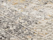 Nahaufnahme eines Designer-Teppichs mit grauen, weißen und beigen Mustern in diagonaler Perspektive.