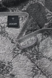 Graues Duschtuch mit geometrischem Muster und Markenetikett, Nahaufnahme