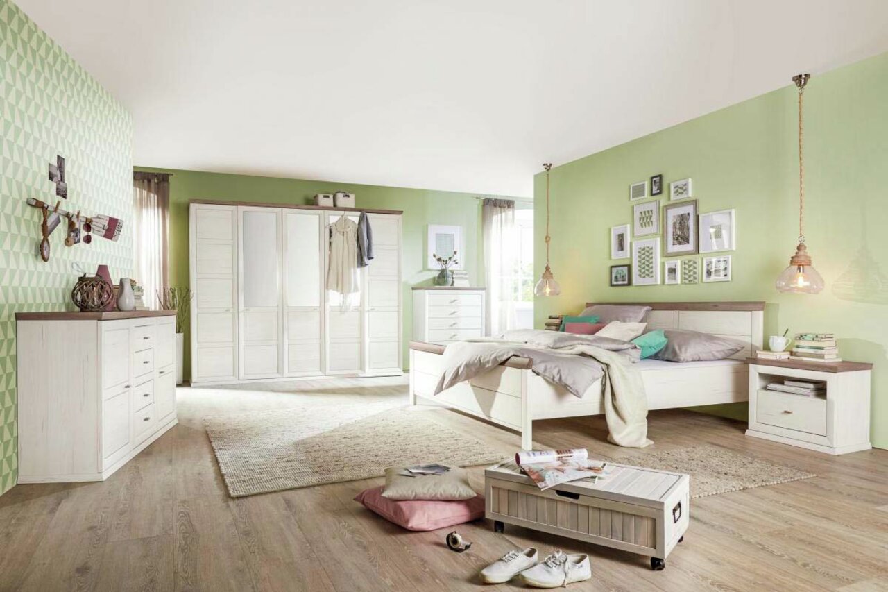 Slaapkamer met een CAMRON-kast met vijf draaideuren in een lichte houtlook, omringd door andere meubels in een modern ingerichte ruimte met groene muurverf. Perspectief: vooraanzicht van de kast.