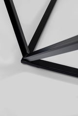 Nahaufnahme eines schwarzen Metallgestells eines Beistelltisches aus der Vogelperspektive.